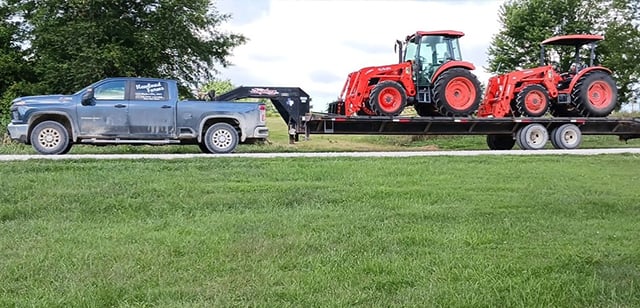 Truck hauling tractors on trailer